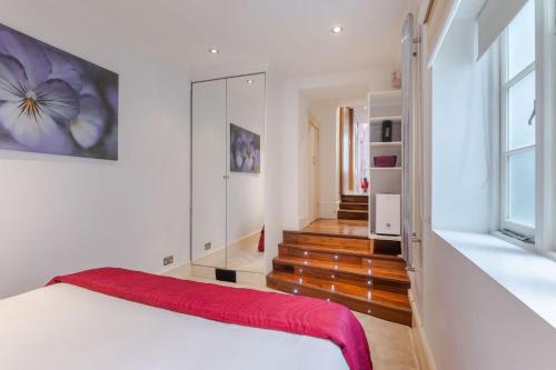 倫敦的住宿－The "Red Room Apartment" - Fitzrovia - by Frankie Says，卧室配有白色的床和镜子