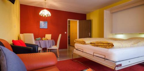 a bedroom with a bed and a dining room at ABA-Sporting Apartment House in Leukerbad