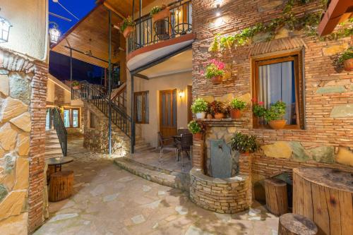 ein Backsteingebäude mit einer Terrasse mit einem Tisch und Stühlen in der Unterkunft Apartments with wine cellar in Old Tbilisi in Tbilisi City