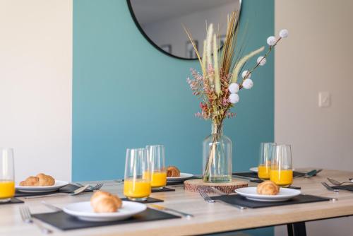 a table with plates of food and a vase of orange juice at 3 Bedroom House Ashford, Kent - Free Parking - Free WiFi - Big Monthly Discounts - Sleeps 5 - Elite Stays UK in Ashford