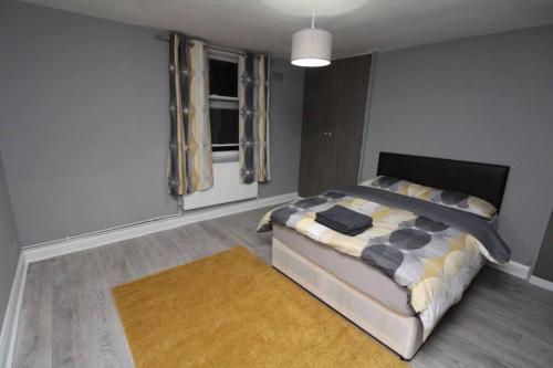 a bedroom with a bed with a rug and a window at Modern 2 Bed Close to City in London