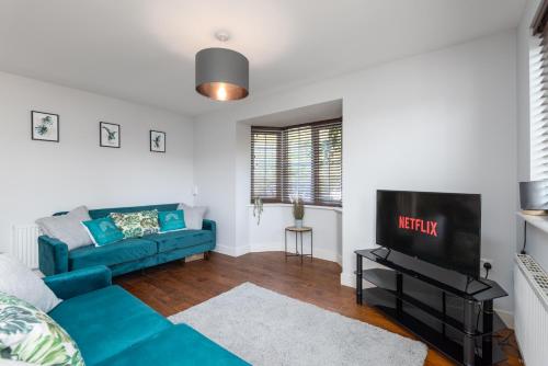 sala de estar con sofá azul y TV en 3 Bedroom House Ashford, Kent - Free Parking - Free WiFi - Big Monthly Discounts - Sleeps 5 - Elite Stays UK, en Ashford