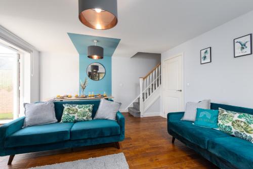 a living room with two blue couches and a staircase at 3 Bedroom House Ashford, Kent - Free Parking - Free WiFi - Big Monthly Discounts - Sleeps 5 - Elite Stays UK in Ashford