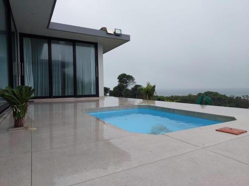 a swimming pool in front of a house at Ntomb'lele Ocean View Luxury Holiday Villas in Tugela Mouth