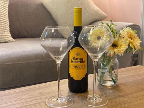 a bottle of wine and two wine glasses on a table at The Old Stable in Shifnal