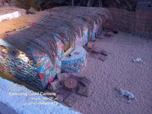 a model of a house with a dog laying on the ground at Perry’s Island Camp Al Mezina in Nuweiba