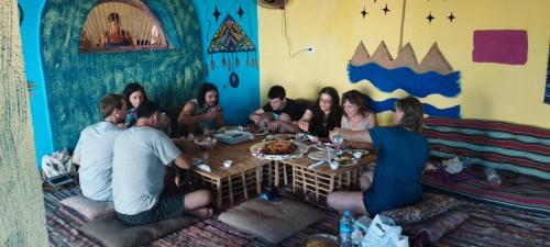 a group of people sitting around a table at Perry’s Island Camp Al Mezina in Nuweiba