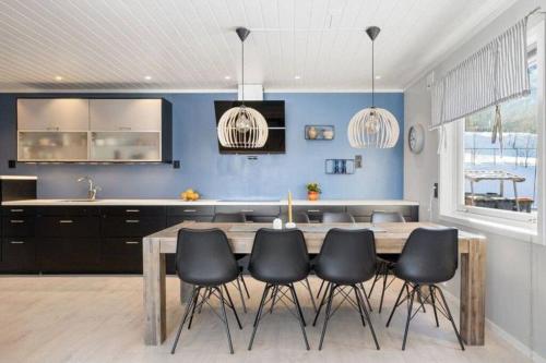 a kitchen with a wooden table and black chairs at Cozy home. Fantastic view and parking in Tromsø