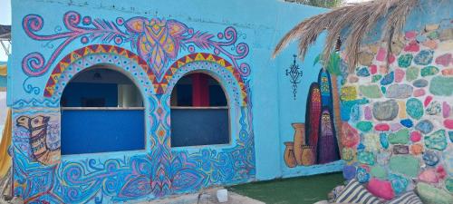a blue building with a painting on the side of it at Perry’s Island Camp Al Mezina in Nuweiba