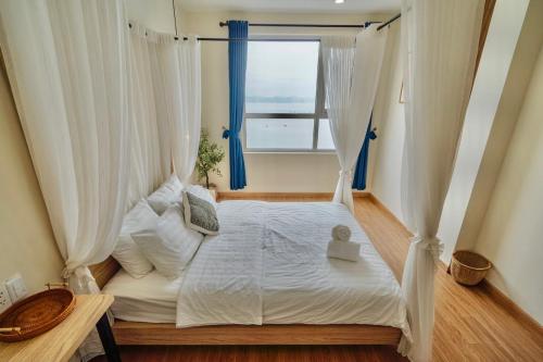 a bedroom with a white bed with a window at The Sapphire Ha Long in Ha Long