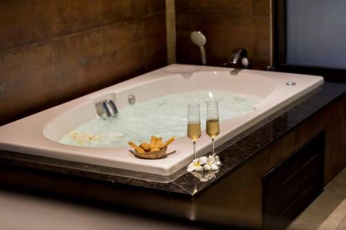 a large bath tub with candles in a bathroom at Villa Mango with staff (brand new) in Amphoe Koh Samui