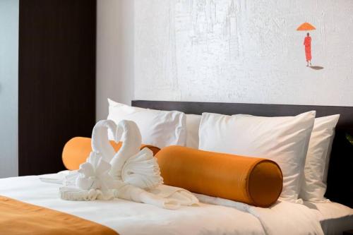 a bedroom with a bed with white and orange pillows at Villa Mango with staff (brand new) in Amphoe Koh Samui