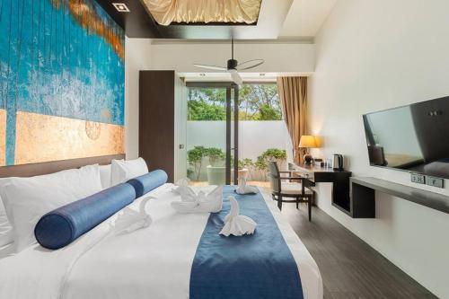 a bedroom with a large white bed with a large tv at Villa Mango with staff (brand new) in Amphoe Koh Samui