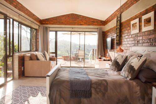 um quarto com uma cama grande e uma sala de estar em Matusadona Guest Lodge em Hillcrest