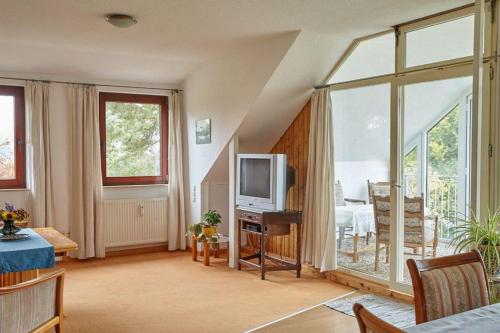 a living room with a large window and a tv at Ferienwohnung Zierau in Amelinghausen