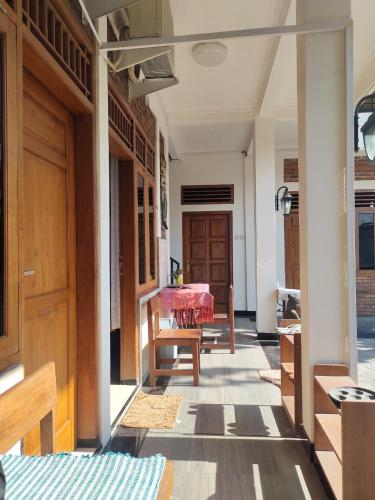 a hallway of a house with a table and a door at Rumah Jati Bantul in Jarakan