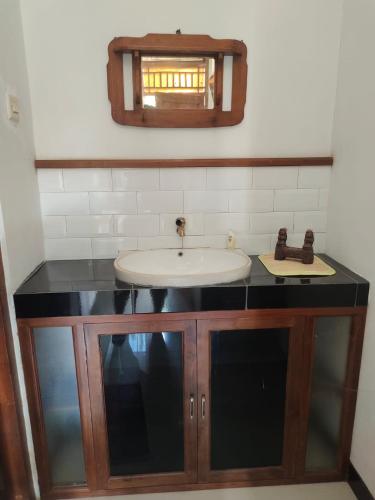 y baño con lavabo y espejo. en Rumah Jati Bantul, en Jarakan