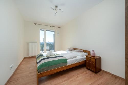 una camera bianca con un letto e una finestra di Wrocław 1-Bedroom Apartment with Parking & Balcony by Renters a Breslavia
