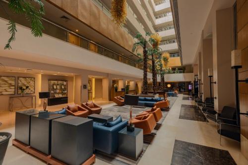a lobby with couches and chairs in a building at Radisson Blu Hotel, Cairo Heliopolis in Cairo