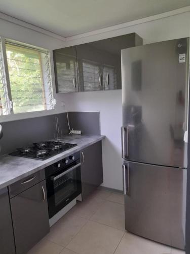 uma cozinha com um frigorífico de aço inoxidável e um fogão em T2 Bambou em Fort-de-France