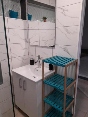 uma casa de banho com um lavatório e um banco ao lado de um espelho em T2 Bambou em Fort-de-France