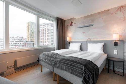 1 dormitorio con cama y ventana grande en Scandic Byporten, en Oslo