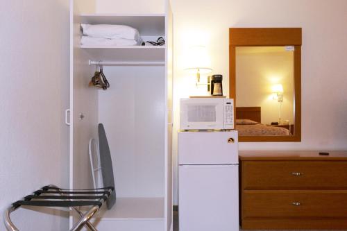 eine kleine Küche mit einem Kühlschrank und einer Mikrowelle in der Unterkunft Town House Motel in Winnemucca