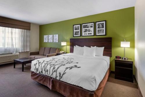 um quarto de hotel com uma cama grande e uma cadeira em Sleep Inn & Suites Pleasant Hill - Des Moines em Pleasant Hill