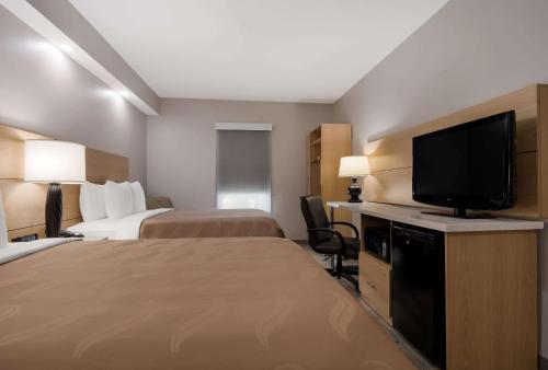 a hotel room with two beds and a flat screen tv at Quality Inn Goldsboro in Goldsboro