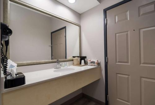 a bathroom with a sink and a large mirror at Quality Inn Goldsboro in Goldsboro