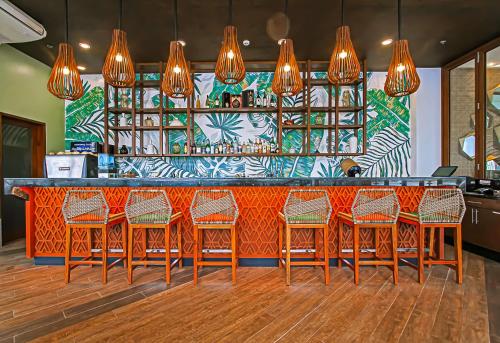 a bar with wooden chairs and a colorful wall at Best Western Plus The Ivywall Resort-Panglao in Panglao