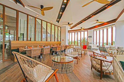 a restaurant with tables and chairs and windows at Best Western Plus The Ivywall Resort-Panglao in Panglao