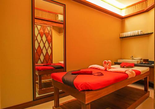 a bedroom with a mirror and a bed with red sheets at Best Western Plus The Ivywall Resort-Panglao in Panglao