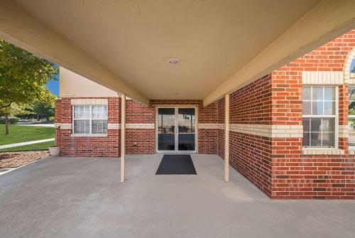 a brick building with a large patio in front of it at Econo Lodge Inn & Suites Mesquite - Dallas East in Mesquite