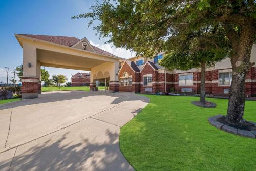 a large building with a driveway in front at Econo Lodge Inn & Suites Mesquite - Dallas East in Mesquite