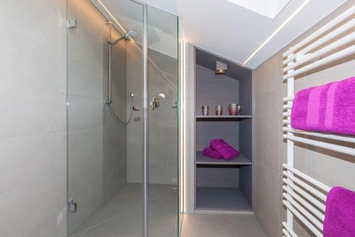 W łazience znajduje się przeszklony prysznic i fioletowe ręczniki. w obiekcie Ferienwohnung in Krün w mieście Krün