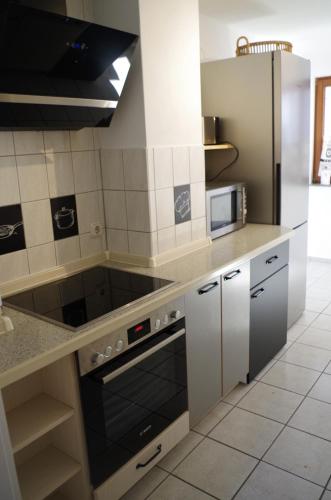 a kitchen with a stove and a microwave at Ferienhaus Friedas Fischerhuus in Maasholm