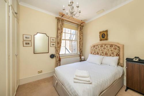 een slaapkamer met een bed en een raam bij The Grand "Old Boy" - Marylebone - by Frankie Says in Londen