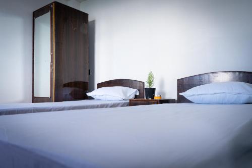 1 dormitorio con 2 camas y espejo en Bastola Basthan Homestay en Darjeeling
