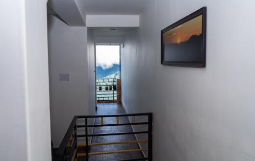 um corredor com uma escada com uma televisão na parede em Bastola Basthan Homestay em Darjeeling