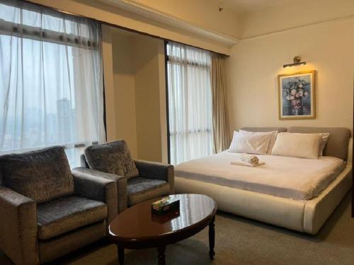 a hotel room with a bed and a chair and a table at Marmaid Suite At Barjaya Time Square KL in Kuala Lumpur