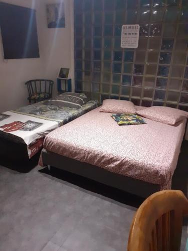 2 camas individuales en una habitación con silla en Tranquillité, en Saint-Joseph
