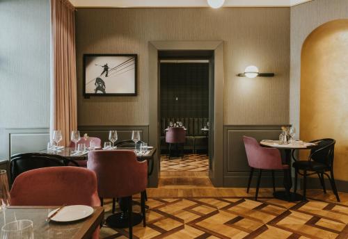 a dining room with two tables and chairs and a doorway at Hotel Saski Krakow Curio Collection by Hilton in Kraków
