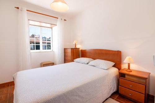 ein Schlafzimmer mit einem weißen Bett und einem Fenster in der Unterkunft Tilli'n'Joe's Beach House in Atouguia da Baleia