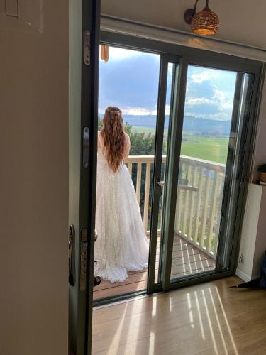 a woman in a wedding dress standing on a balcony at צימר חלון לרקפות zimer Window for primroses עם ג'קוזי לנוף in Tal Shaẖar