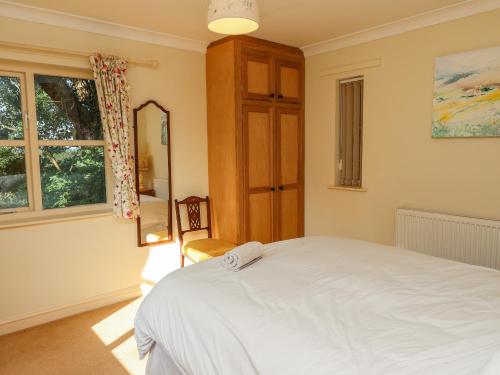 a bedroom with a white bed and a mirror at Hill Top Cottage in Welbourn