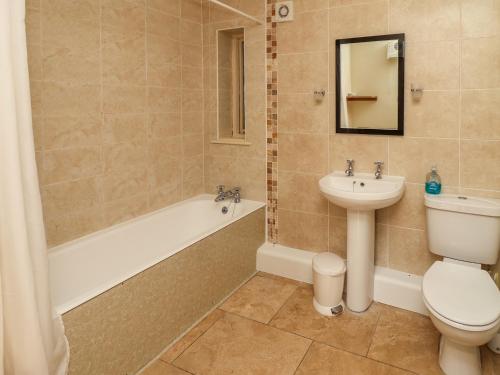 a bathroom with a toilet and a sink and a tub at Hill Top Cottage in Welbourn