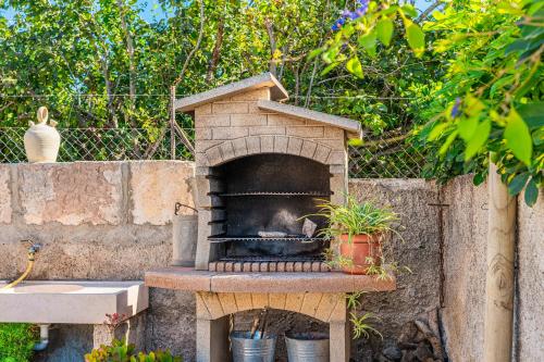 a stone pizza oven with a fire in it at Son Serra in Búger