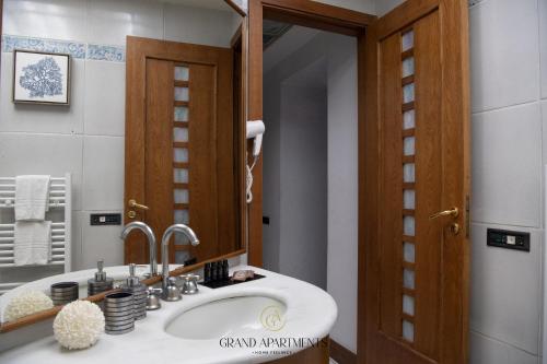 a bathroom with a sink and a mirror at Grandapartments via Duomo Napoli in Naples