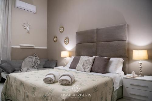 a bedroom with a large bed with two towels on it at Grandapartments via Duomo Napoli in Naples